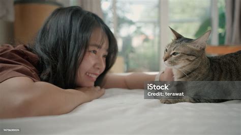 Asiatische Frau Die Eine Süße Katze Auf Einem Weißen Bett Im