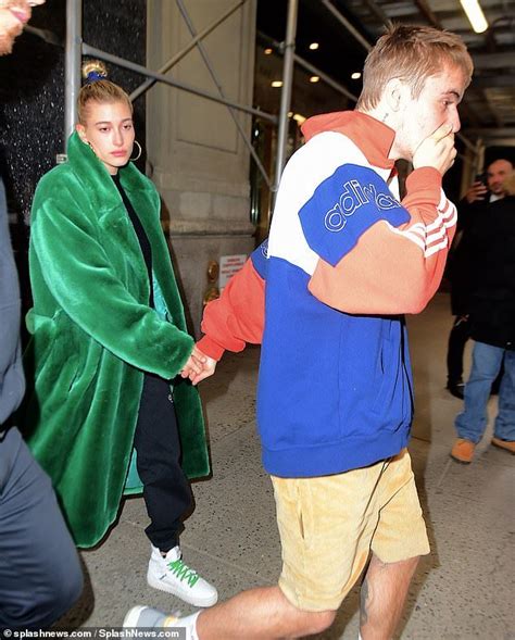 together bieber led his wife out past the waiting paparazzi by the hand as he brushed his