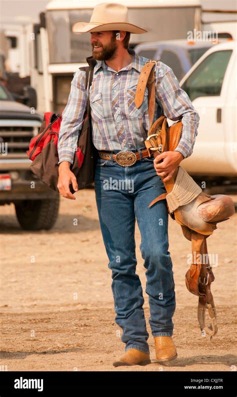 Cowboy Bronc Rider Carrying His Saddle To The Rodeo Arena Bruneau