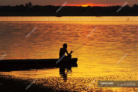 Silhouette Of Man Sitting In A Boat And Fishing At Sunset — Water 55