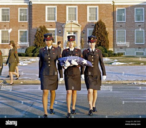 Three Female Marines In Dress Blue Uniforms Raise The Morning Colors