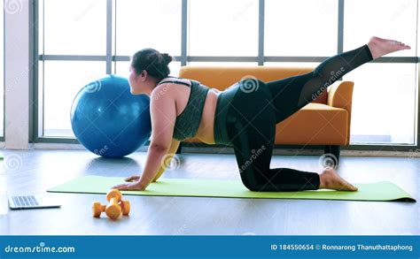 Chubby Woman Doing Exercise By Stretching At Fitness Stock Photo