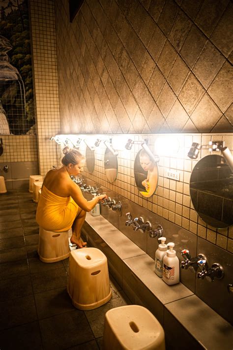 A Woman In A Yellow Dress Is Sitting On A Stool Next To A Row Of Urinals
