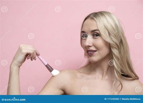 Beautiful Blond Woman With Naked Shoulders Holding Brush On Pastel Pink