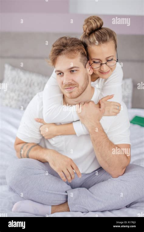 Good Looking Couple Embraces Passionately Sits On Comfortable Bed