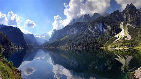 Landscape Photography Of Lake Between Mountain Range Under Blue Sky And