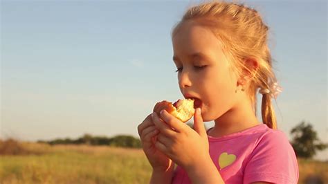 Cute Kid Girl Eating Sweet Donut Outdoor In Stock Footage Sbv Storyblocks