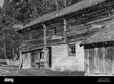 A Black And White Photograph Of An Old Wooden Building In A Rural