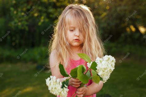 꽃과 함께 여름에 야외에서 어린 소녀의 초상화 프리미엄 사진