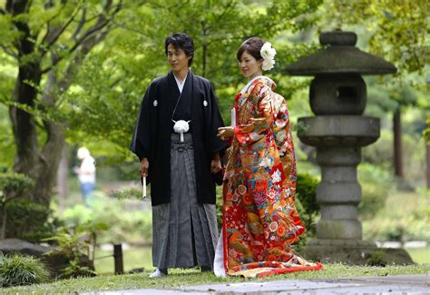 A Newlywed Couple Dressed In Japanese Traditional Wedding Attire Pose For A Photograph In