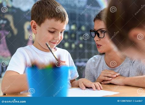 Preschool Teacher Looking at Smart Child at Kindergarten Stock Image