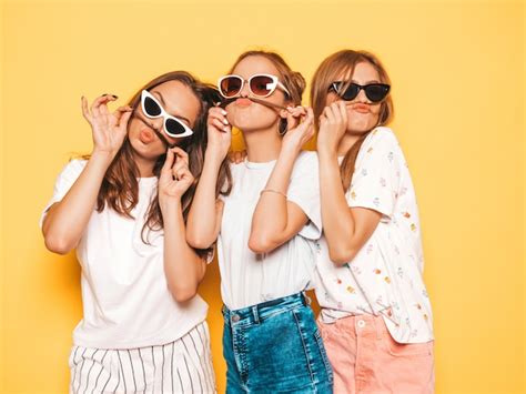 trzy młode piękne uśmiechnięte hipster dziewczyny w modne letnie ubrania seksowne beztroskie