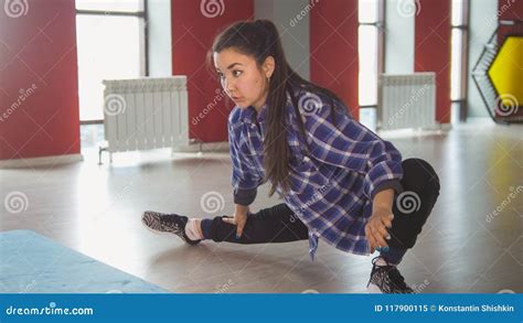 Attractive Female Brunette Stretching In Fitness Room Stock Image