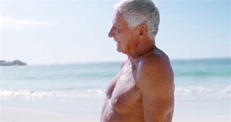 Retired Old Man Standing While Looking Away On The Beach Stock Footage