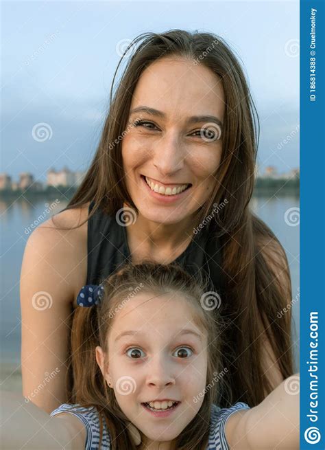 mom and daughter take selfies and look directly at the camera they are smile beautifully and