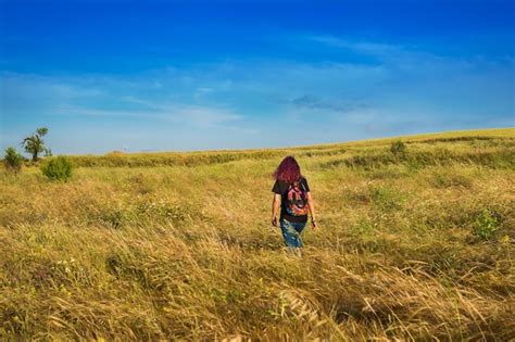 Premium Photo A Girl Walking Through A Field Of Tall Grass