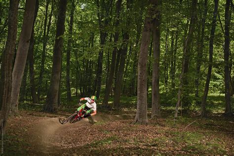 Man Riding Dirt Bike With Cornering Technique Through The Woods Del Colaborador De Stocksy