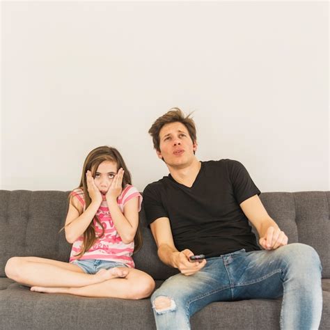 Free Photo Scared Girl Sitting Near Her Father On Sofa