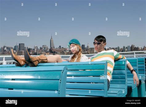 Two People Sitting On Benches Stock Photo Alamy