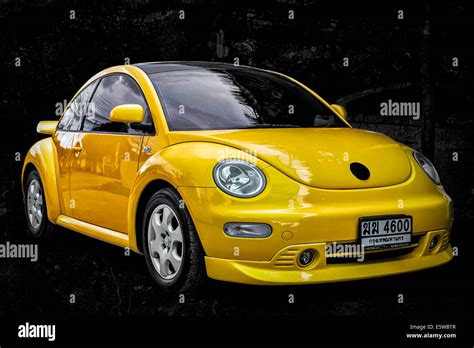 Vivid Yellow Modern Volkswagen Vw Beetle Motorcar Against A Black Stock