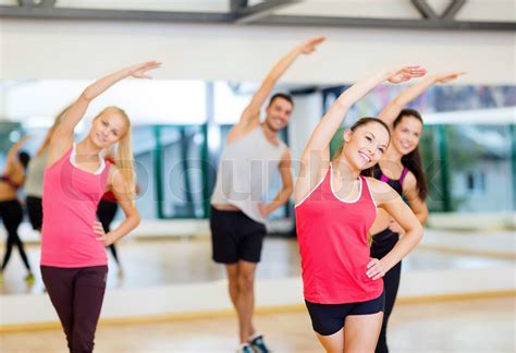 group of smiling people stretching in the gym stock image colourbox