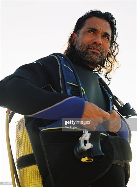 Low Angle View Of A Man In Scuba Gear Fastening His Jacket High Res
