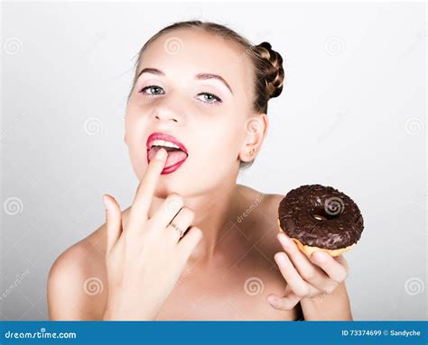 Young Woman In Bright Makeup Eating A Tasty Donut With Icing Funny