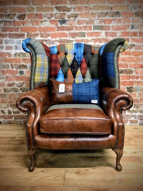 A Leather Chair With Colorful Pillows On It In Front Of A Brick Wall