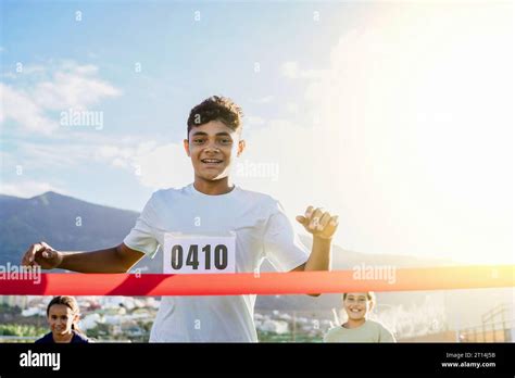 Teenager Man Runner Crossing Finish Line During Race Marathon