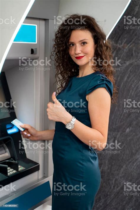 Atm 기계 옆에 서있는 동안 엄지 손가락을 보여주는 소녀 세에 대한 스톡 사진 및 기타 이미지 iStock