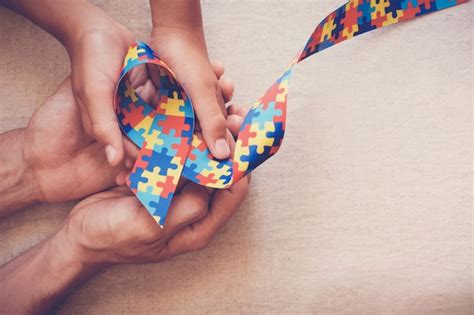 Premium Photo Hands Holding Puzzle Ribbon For Autism Awareness