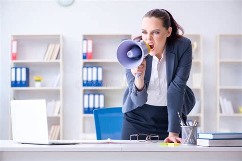 The Angry Businesswoman Yelling With Loudspeaker In Office Stock Photo