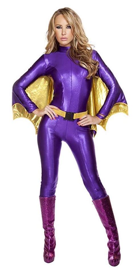 A Woman In A Purple And Gold Costume Is Posing For The Camera With Her Hands On Her Hips