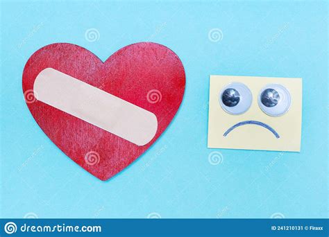 Sad Emoticon Looking At A Heart With A Medical Plaster First Aid Take
