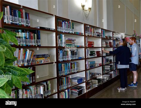 Western Tourists Perusing Shelves Of English Language Books
