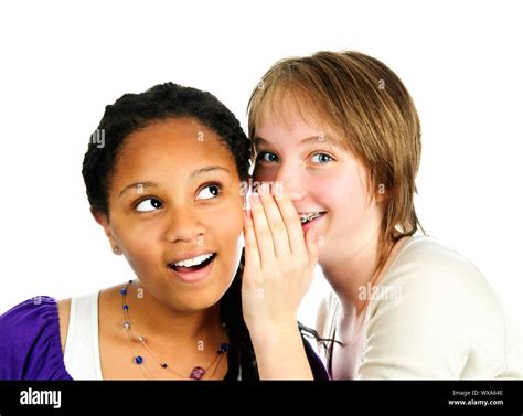 Isolated Portrait Of Two Diverse Teenage Girl Friends Whispering Stock
