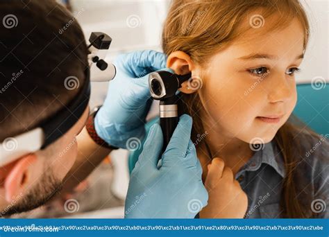 Ent Doctor Otolaryngologist Looks Through Otoscope The Ears Of A Little