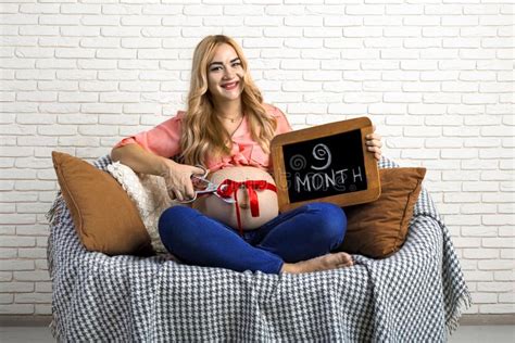 pregnant girl with a sign and a ribbon on the belly big belly ninth month obraz stock obraz