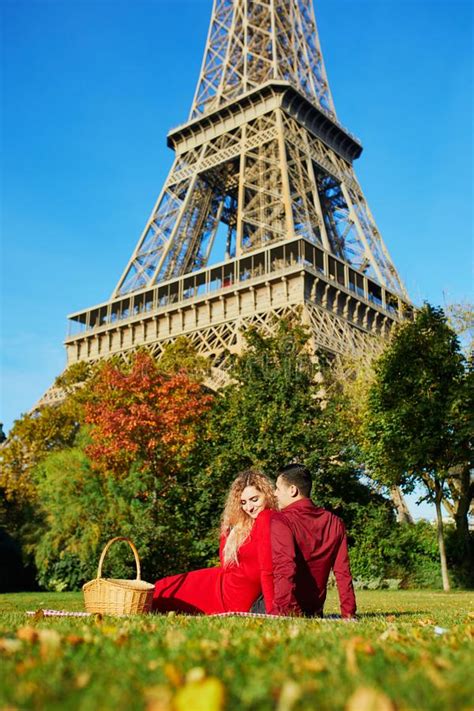 Romantic Couple Having Picnic On The Grass Near The Eiffel Tower Stock