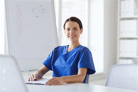 Happy Female Doctor Or Nurse Writing To Clipboard Stock Photo Image