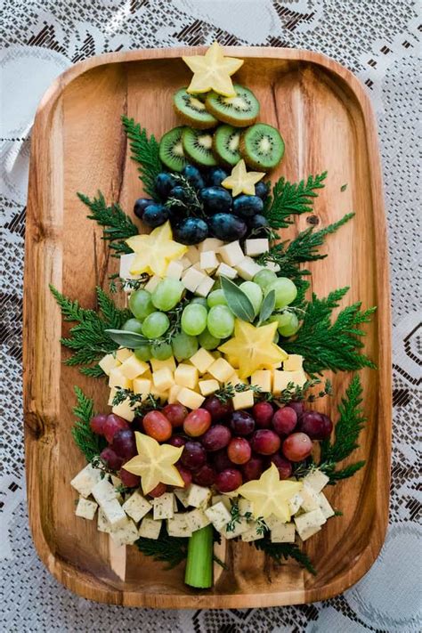 Finger foods are the best for keeping your guests satisfied until the main meal is served. Christmas tree shaped cheese platter on a wooden tray kiwi ...