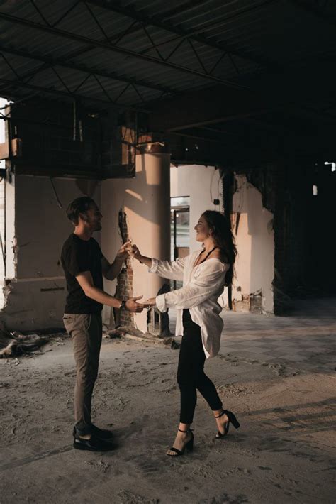 A Man And Woman Holding Hands In An Abandoned Building