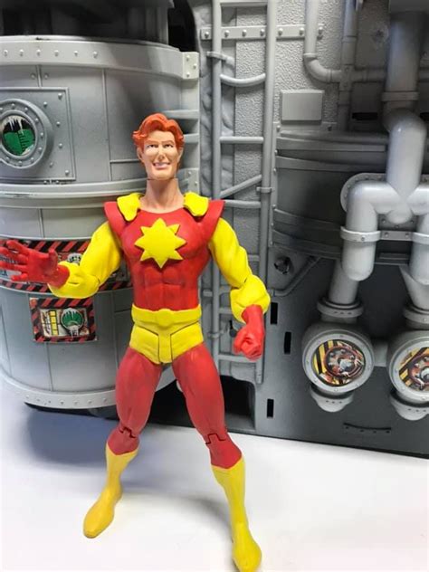 The Action Figure Is Posed In Front Of A Machine