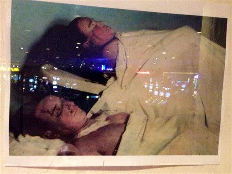 An Old Photo Of Two People Laying In Bed With City Lights In The Back Ground