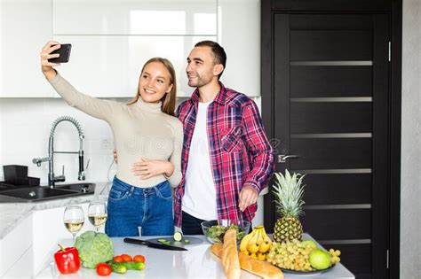 Portrait Of A Smiling Young Couple Taking A Selfie While Cooking