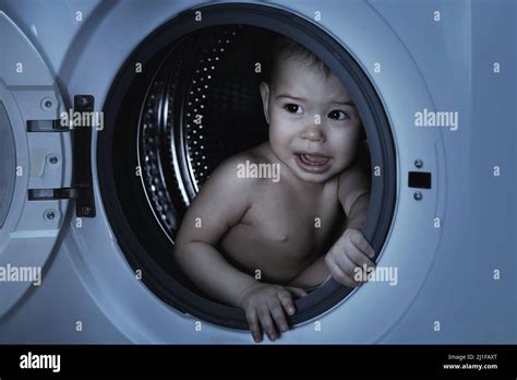 Scared Baby Boy Sitting Inside The Washing Machine Stock Photo Alamy