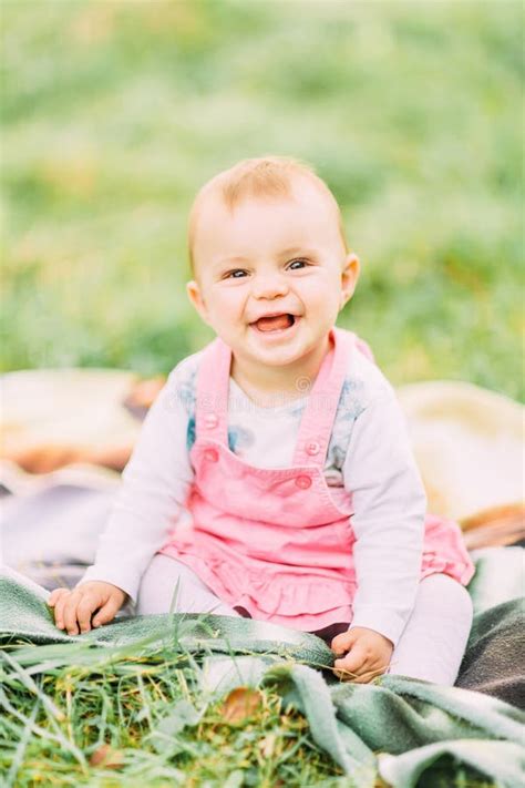 Portrait Of Happy Joyful Child In Pink Dress Over Green Grass