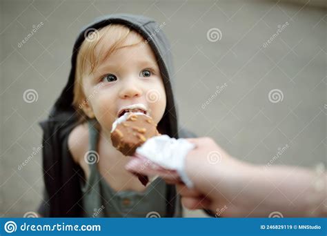 Cute Toddler Boy Eating Tasty Fresh Ice Cream Outdoors On Warm Sunny