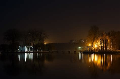 Lake At Night With A House And Lights Photo Free Download