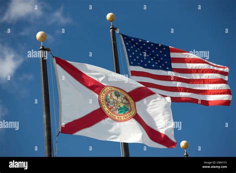 Florida State Flag United States Flag Flying On Flagpoles On Blue Sky